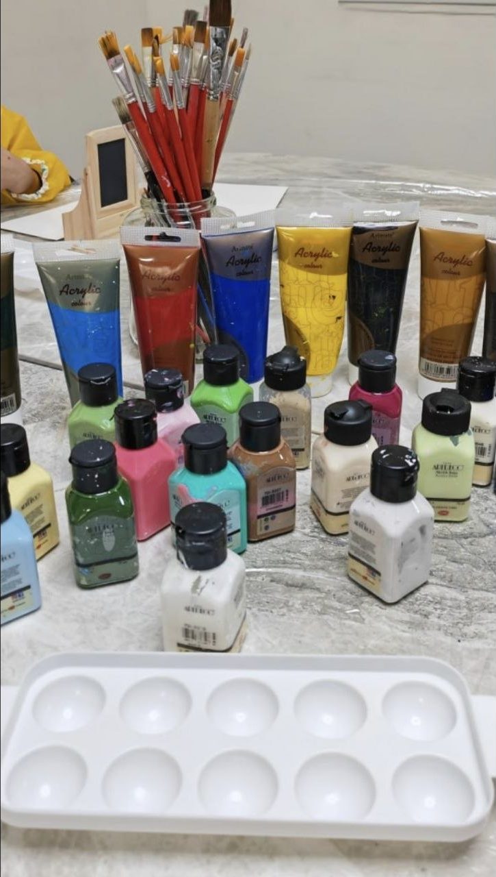 Acrylic paint tubes and bottles with brushes and a palette